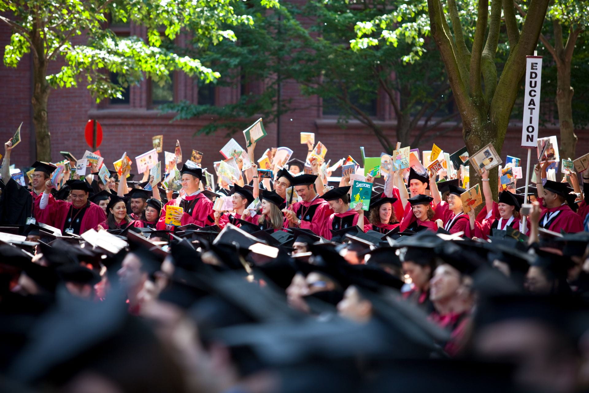 A view of graduates across Harvard Yard, wearing caps and gowns.